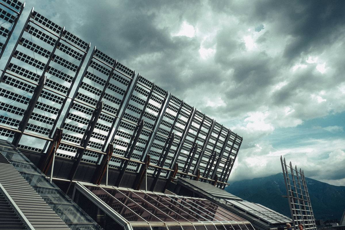 Aerial view of solar panels for commercial buildings installed on a flat warehouse roof with proper spacing around HVAC units