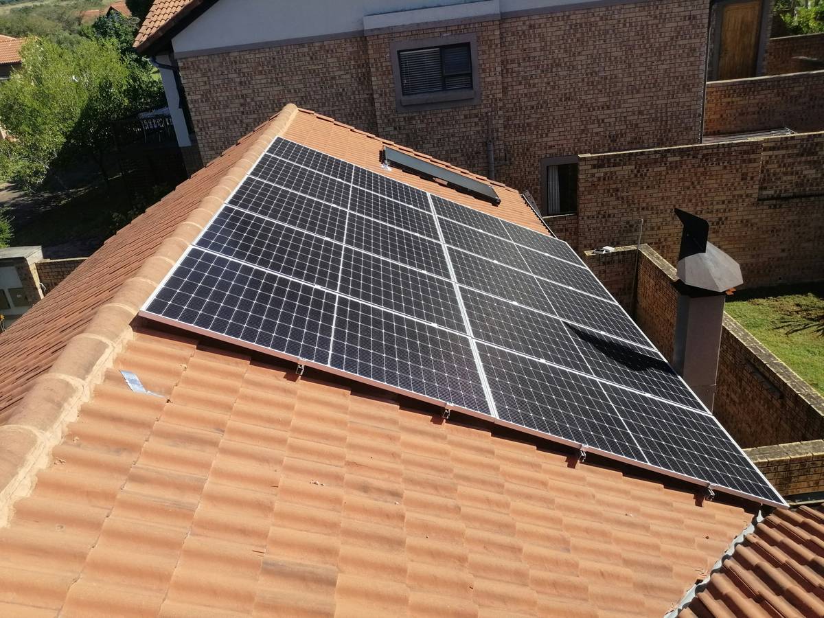 Aerial view of commercial solar panel systems installed on a warehouse rooftop with clear labeling and spacing