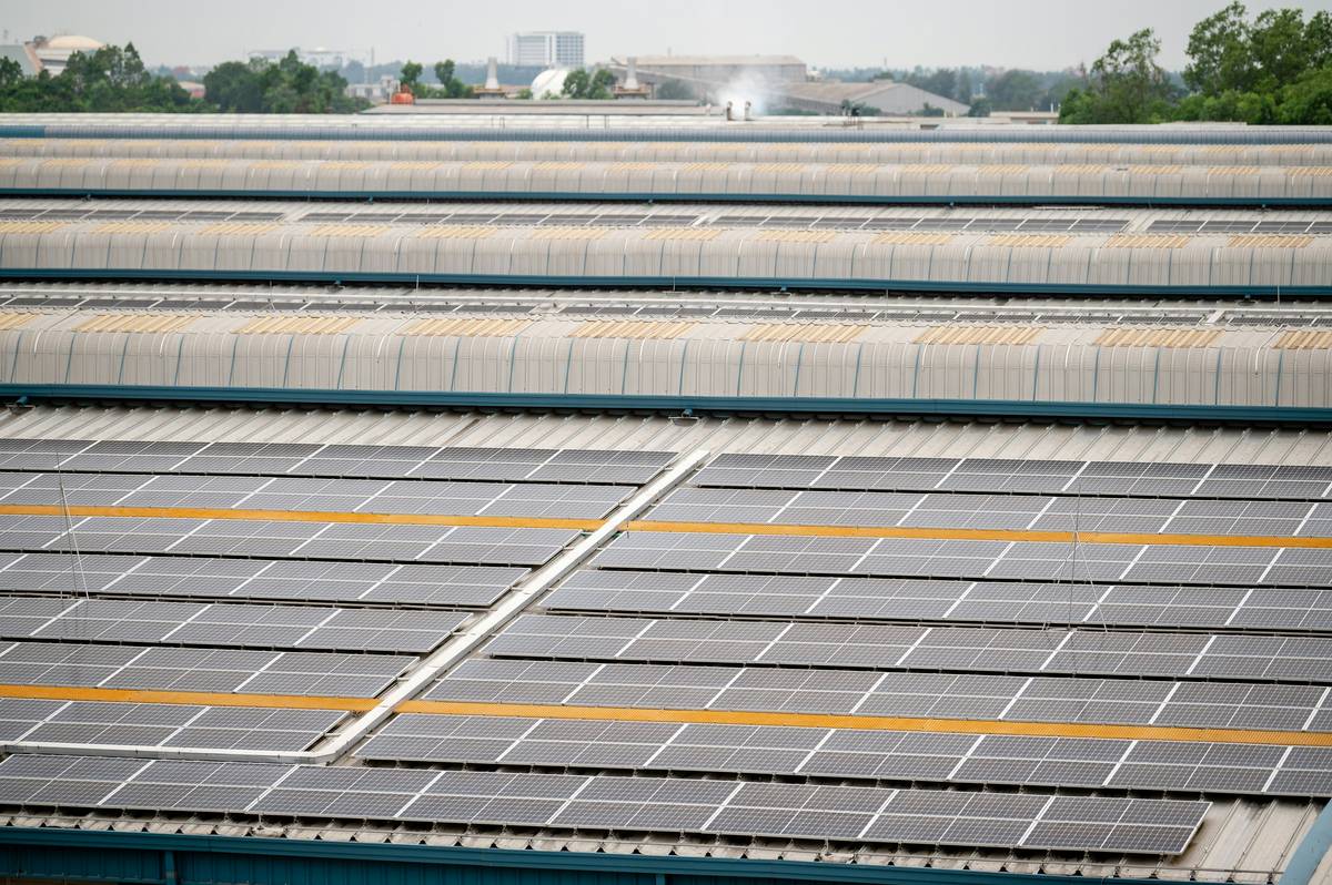 solar for commercial business rooftop installation with technicians assessing panel alignment