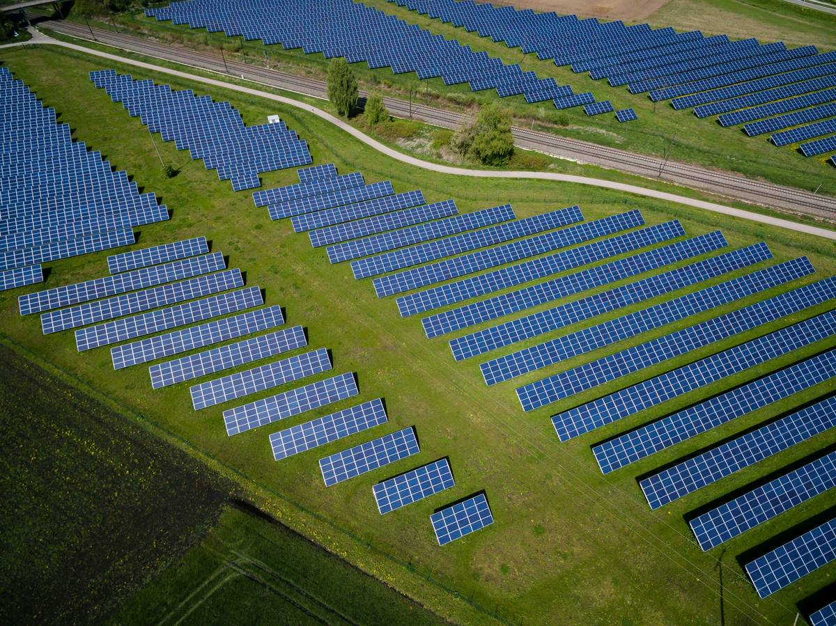 Commercial roof solar panels installed on a flat industrial building with city skyline in background
