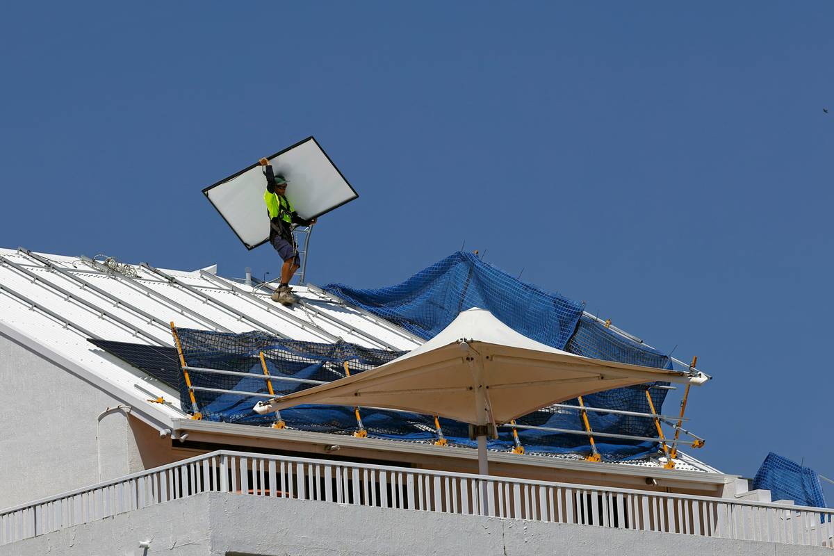 Technicians receiving hands-on training for solar panel installation on a commercial rooftop mockup