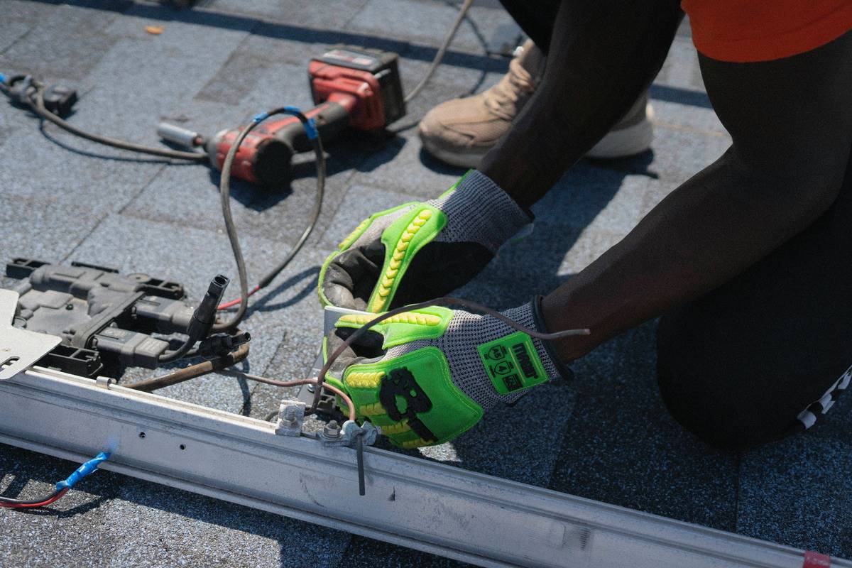 Commercial solar panel construction on a flat commercial rooftop with technicians installing mounting rails